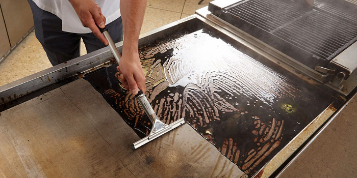 Image of a man cleaning a griddle