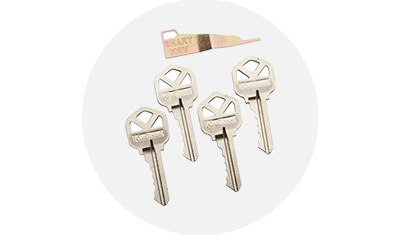 Kwikset Keys, 5 total, isolated on top of a gray circle