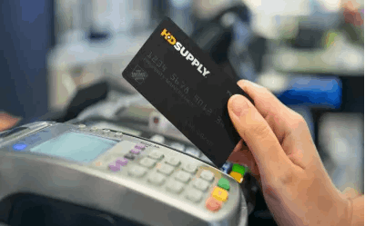 Hand holding ProPurchase Card above credit card machine on a table