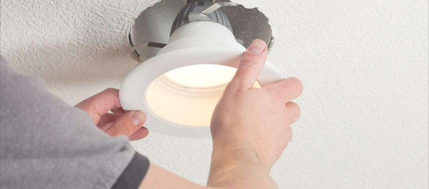 Hands insert a ceiling can light.