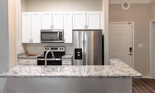 White and grey kitchen with counter top and full appliance package visible.